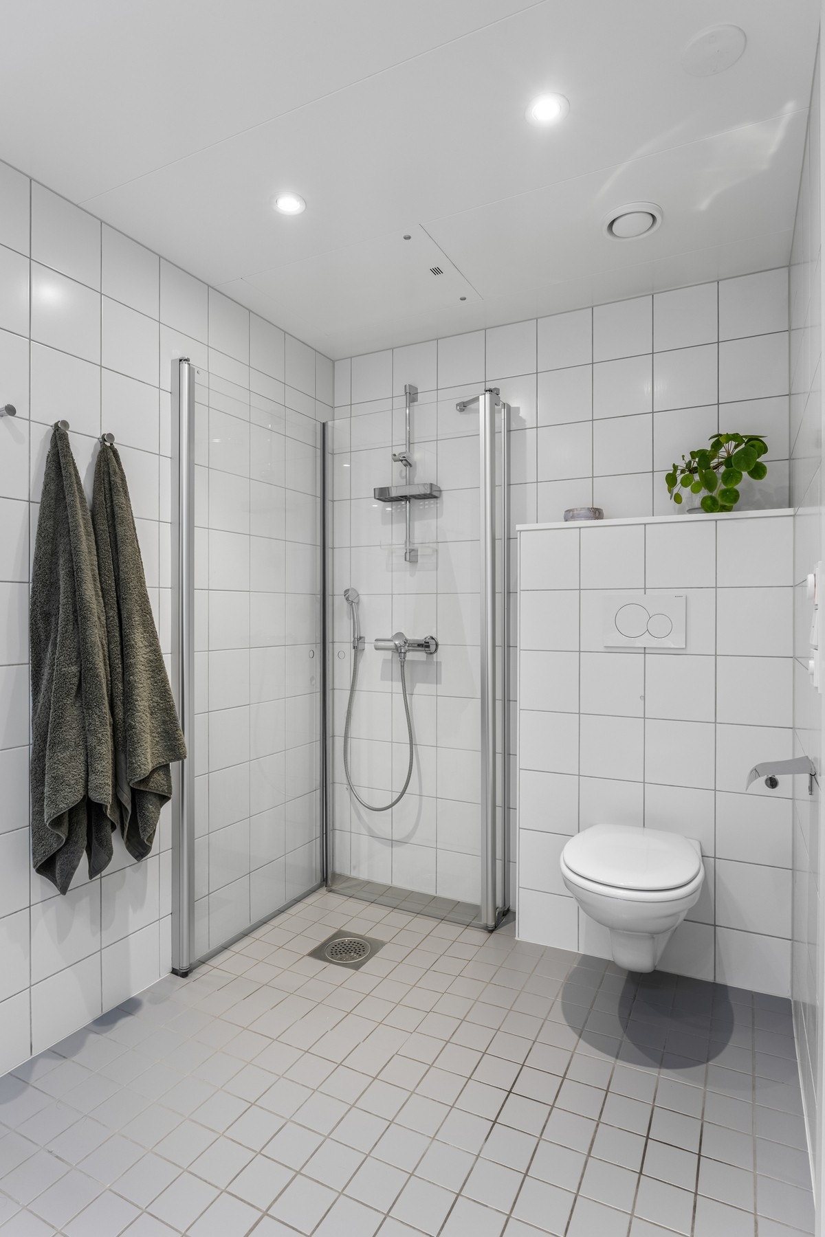 Dusjsonen er adskilt med to skyvbare glassdører og det er innebygget sisterne med vegghengt toalett. Galleribilde