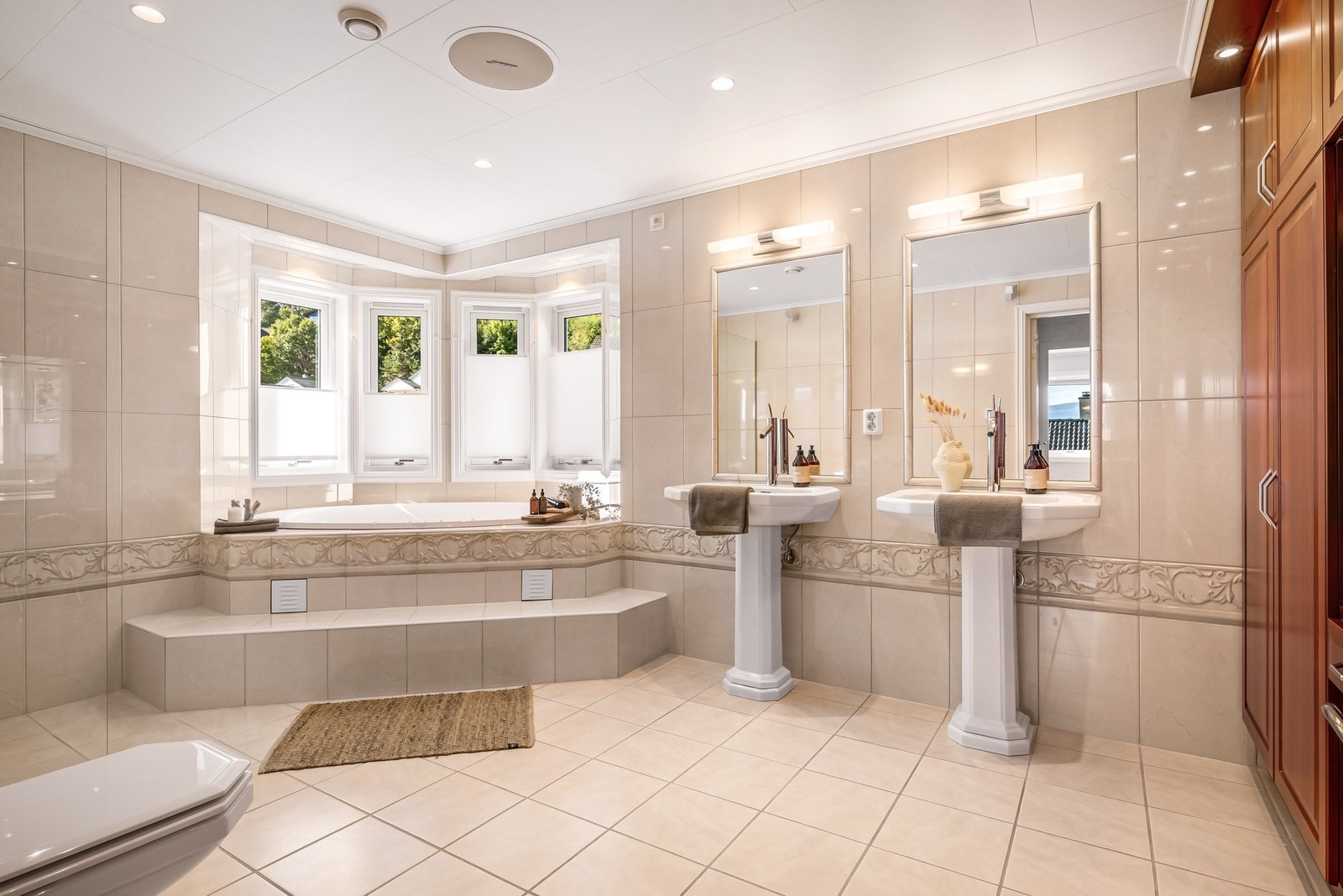 - Badet er hele ca. 14,4 m² og er innredet med vegghengt toalett, Hurricane massasjebad, dusj i glassnisje og to servanter med Hansgrohe Axor armatur, storte innflisede speil og belysning - Galleribilde