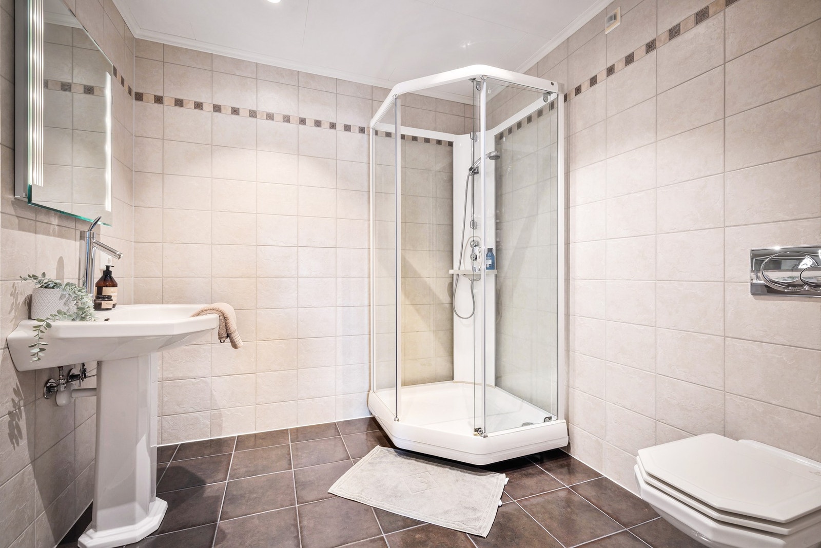 - Badet i hoveddelens underetasje har keramiske fliser på gulv og vegger, vannbåren gulvvarme, LED-spotter og elektrisk avtrekk - Galleribilde