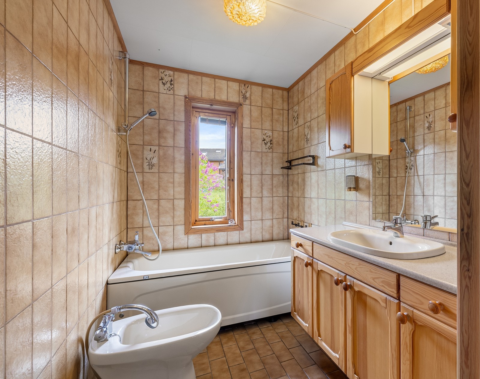Etasjen har et bad med fliser på gulv og vegger. Standarden er eldre, og renovering må påregnes. Galleribilde