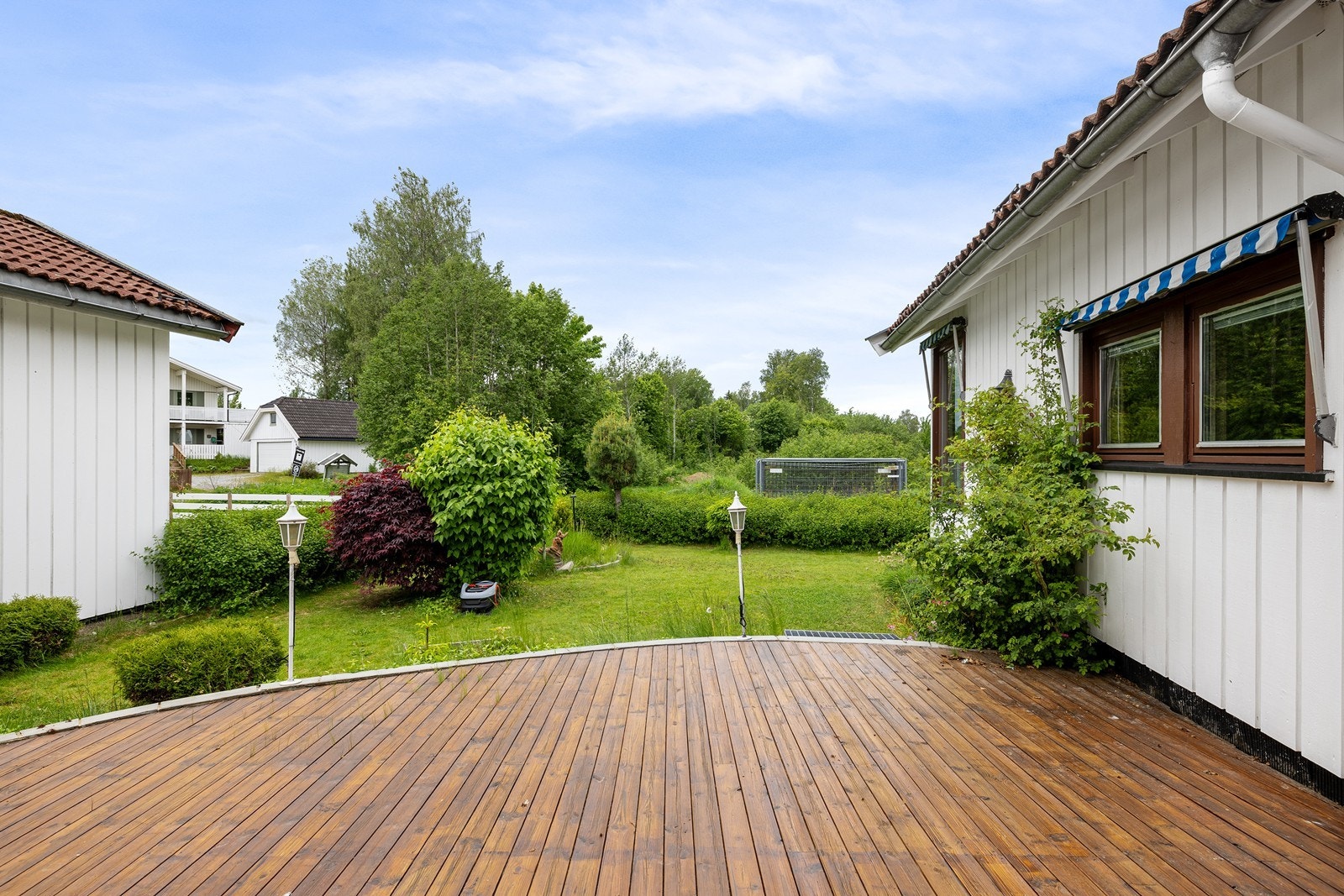 Fra mellomgangen mellom entré og stue er det utgang til terrasse med tregulv. Uteplassen måler 27 m², og har god plass til sittegruppe samt grill. Galleribilde
