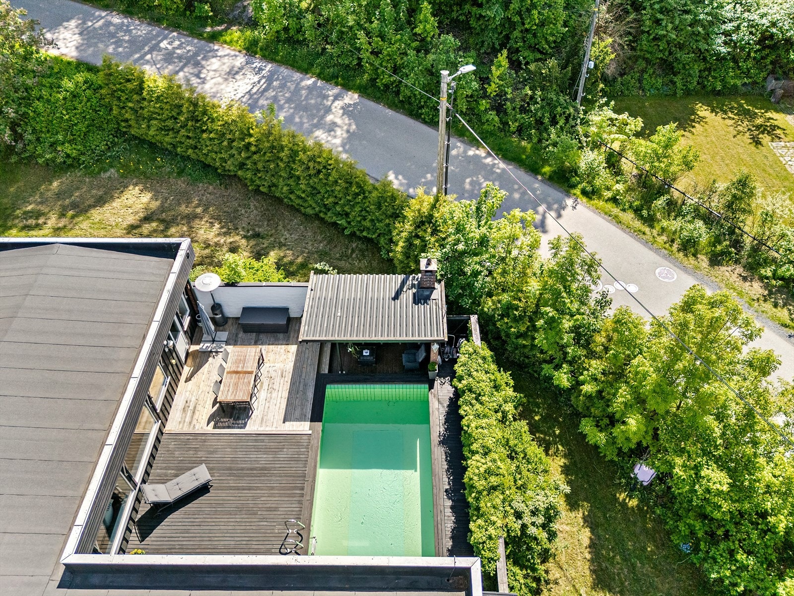 Oversiktsbilde av eiendommen viser terrassen og svømmebassenget. Galleribilde
