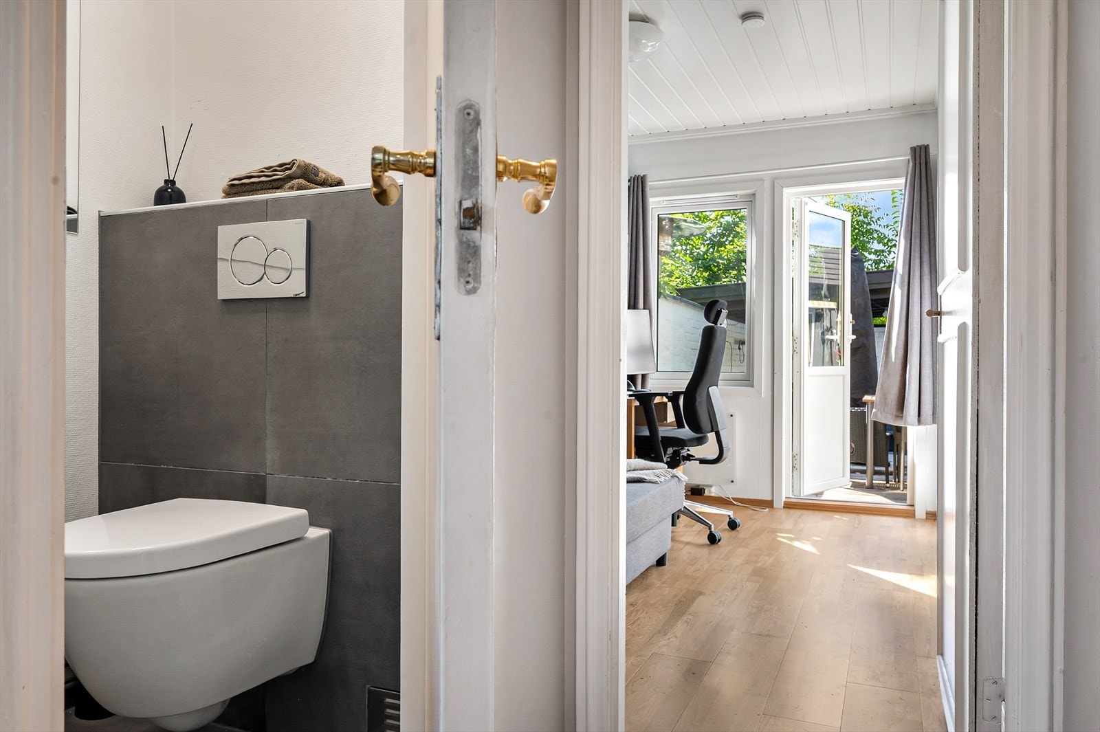 Toalettrommet har vegghengt WC og moderne overflater med fliser og malte flater. Galleribilde