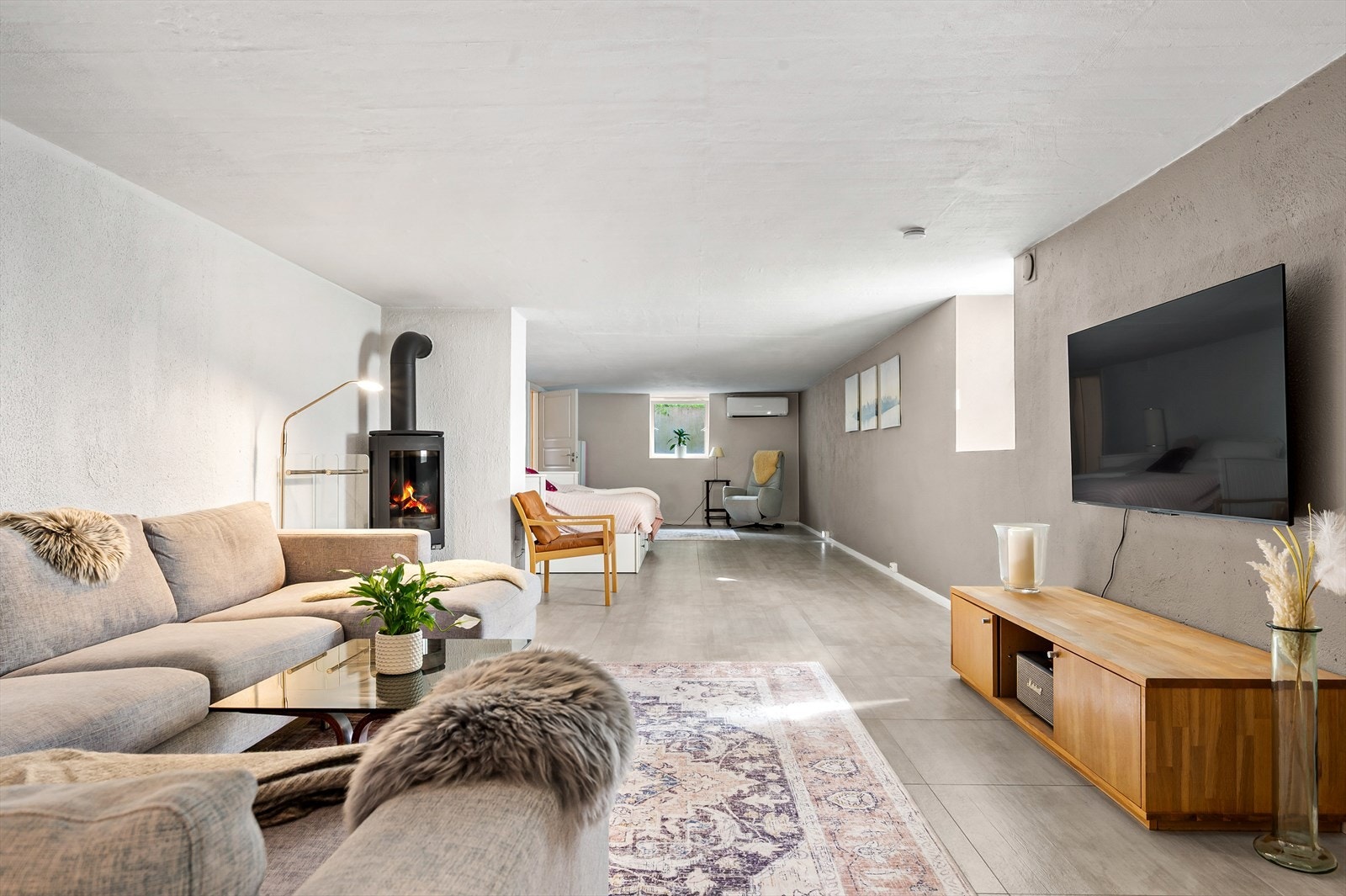 Kjellerstuen har peis som sikrer effektiv oppvarming. Det er også varmekabler i hele gulvet i kjellerstuen. Galleribilde