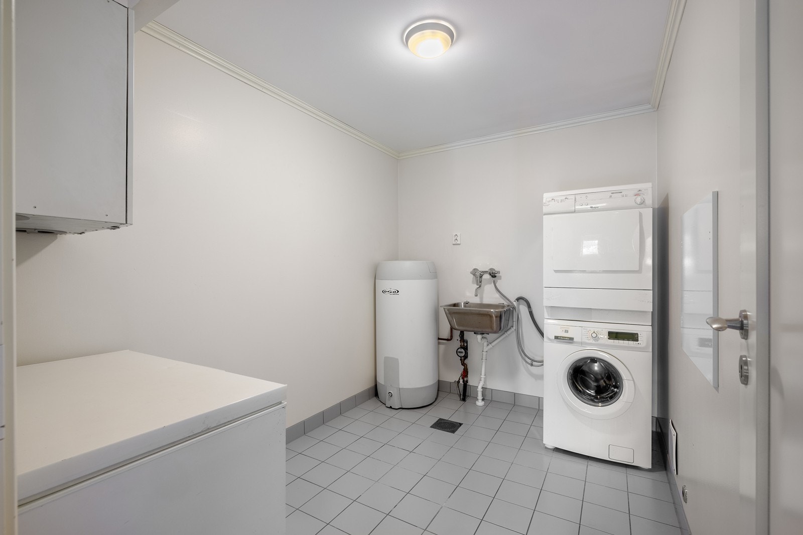 Praktisk vaskerom med opplegg for vaskemaskin og tørketrommel, utslagsvask og gode bruksmuligheter. Galleribilde