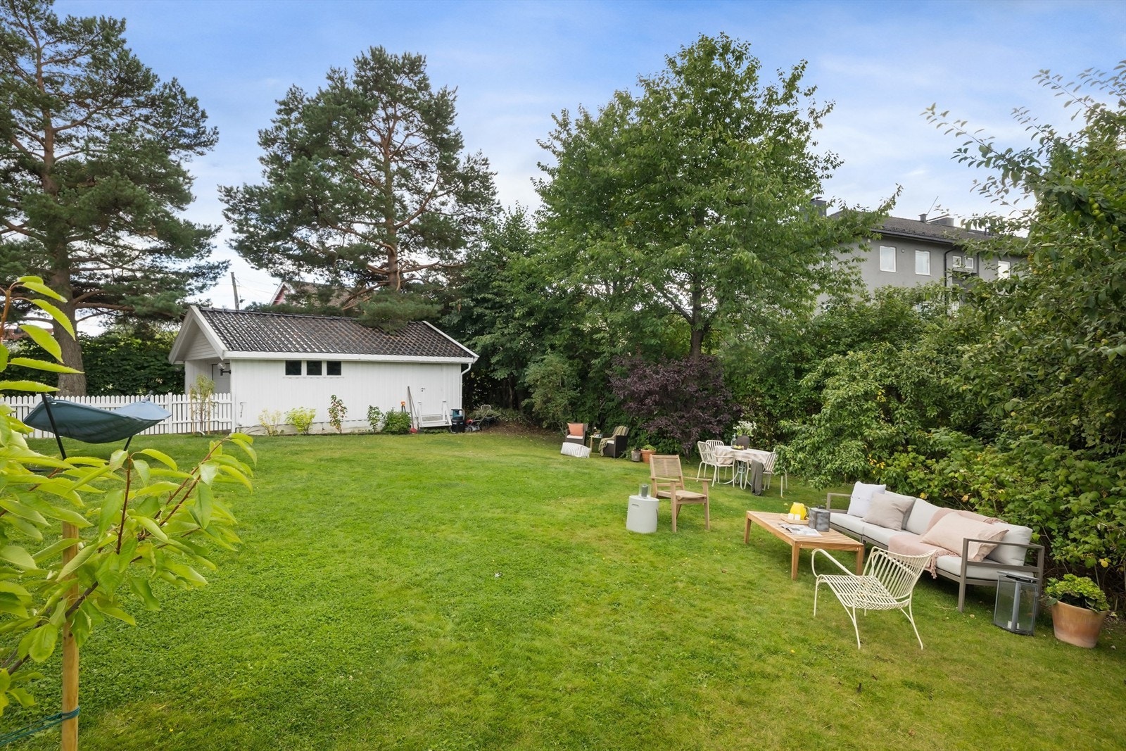 Her kan du leve hagedrømmen i en idyllisk hage med frodig gressplen omkranset av grønn, tett beplantning Galleribilde