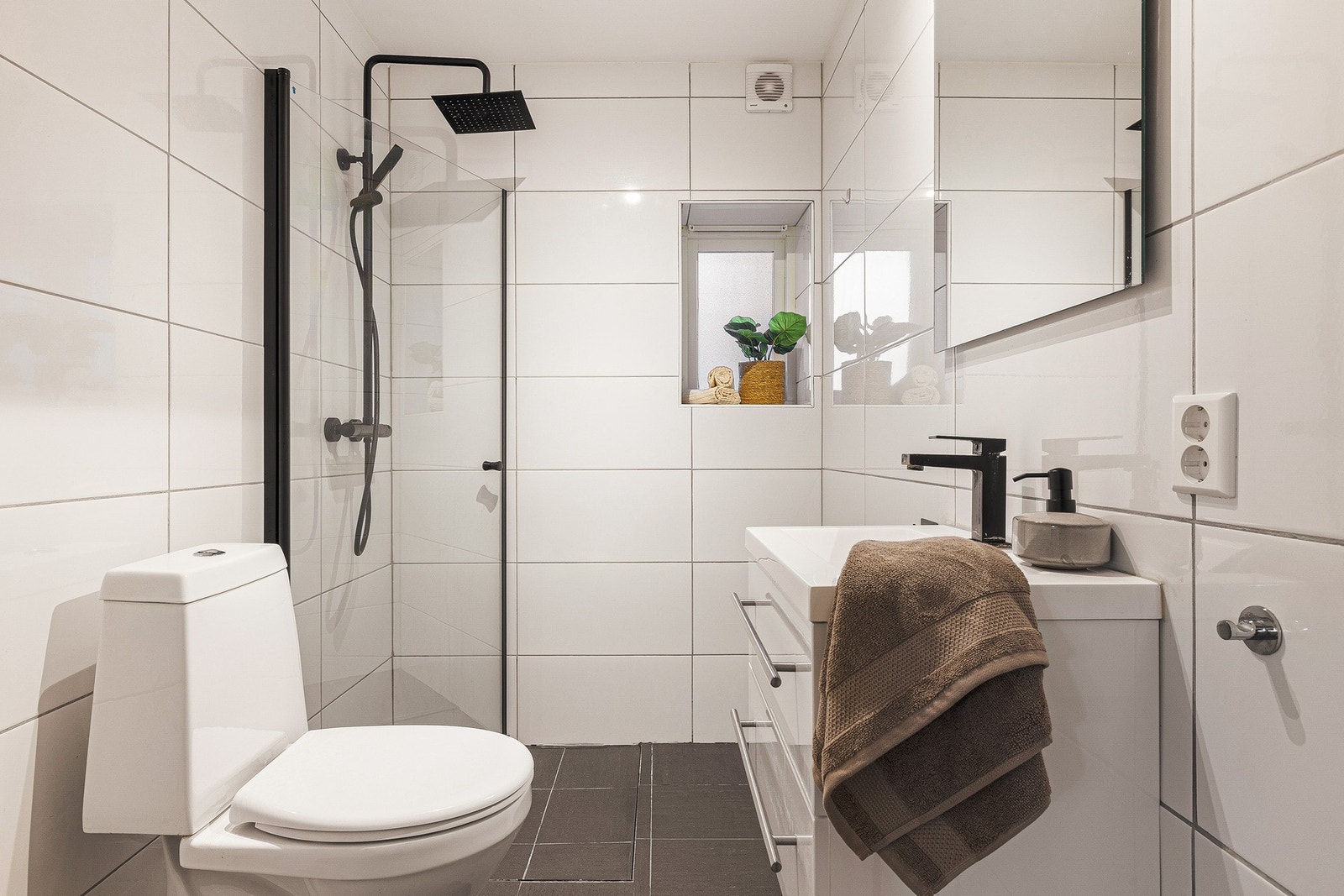 Badet inneholder servantinnredning, toalett, gulvvarme og opplegg for vaskemaskin. Galleribilde