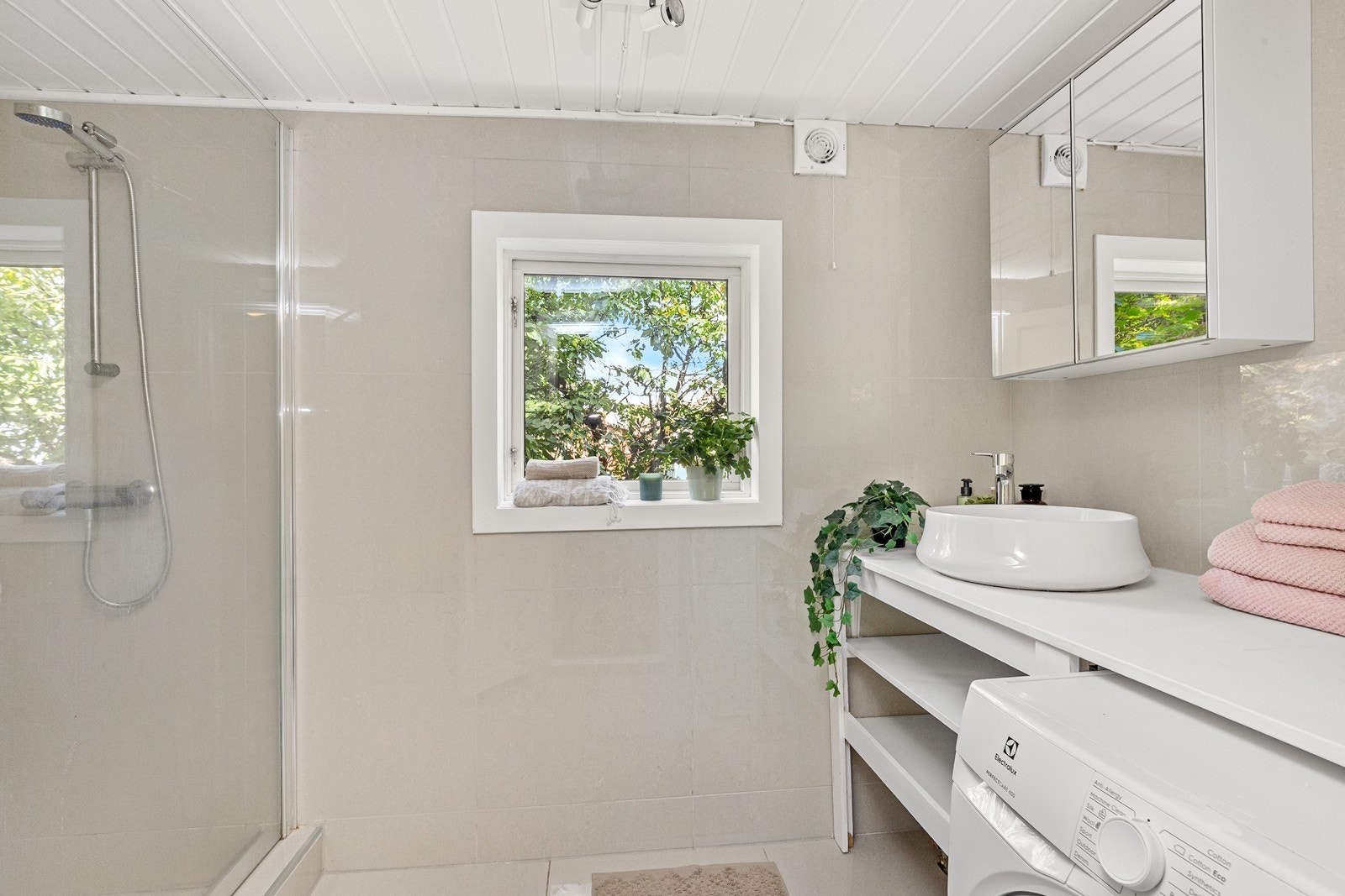 Badet har vegger med fliser og tak med malt trepanel, og ventilasjonen er basert på elektrisk avtrekksvifte. Galleribilde