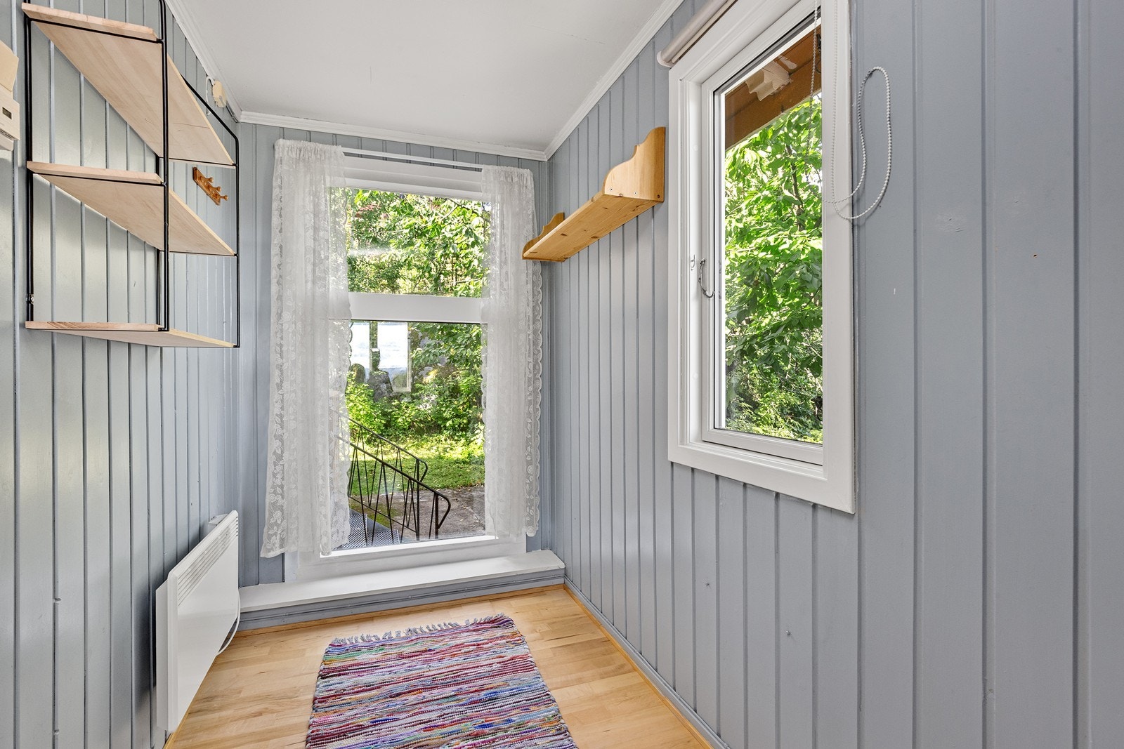 Vegger med malt trepanel gir et klassisk preg, kombinert med parkettgulv for et solid underlag. Galleribilde