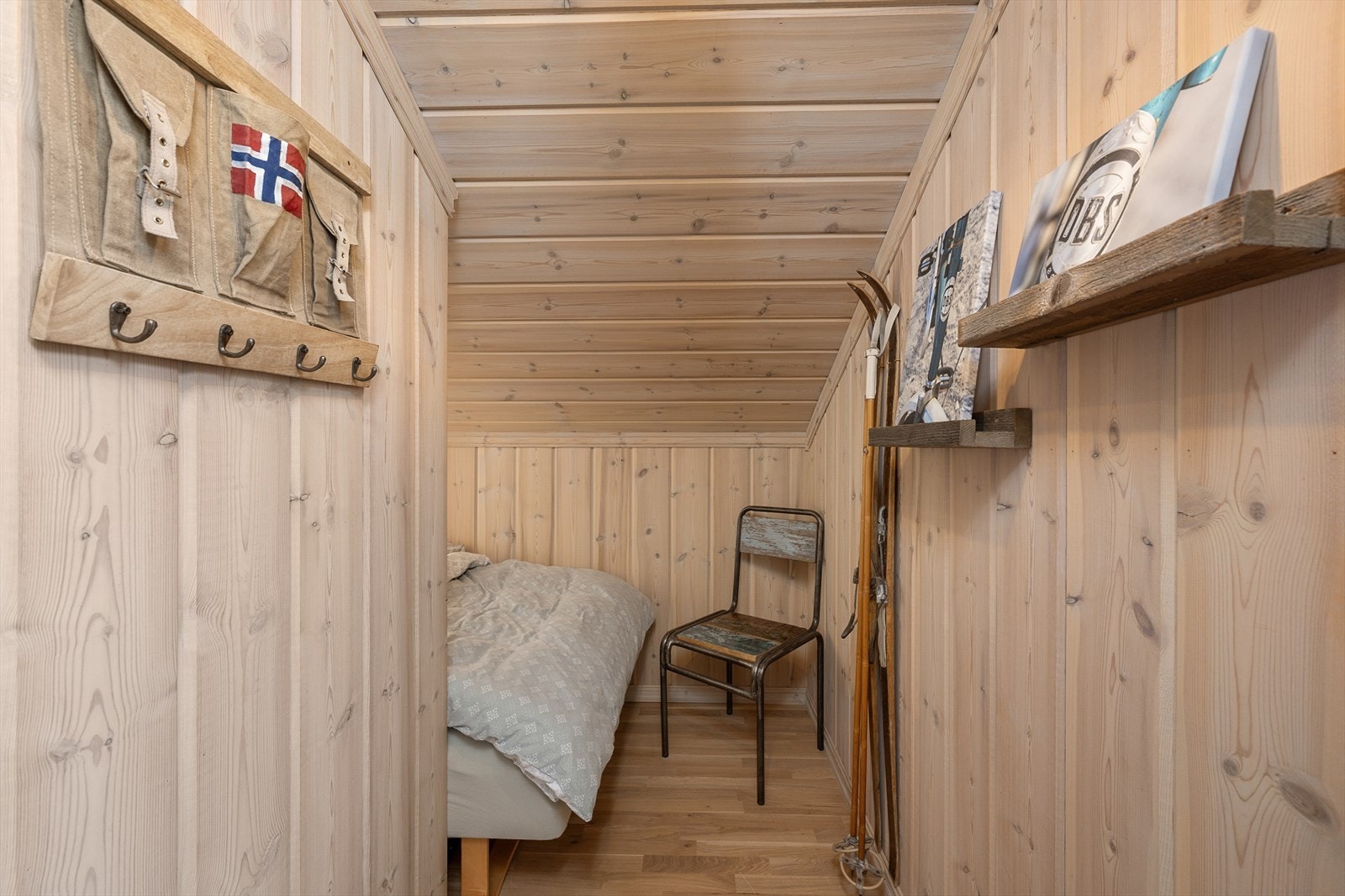 Ett soverom går i vinkel og har sengen plassert innerst i rommet. Galleribilde