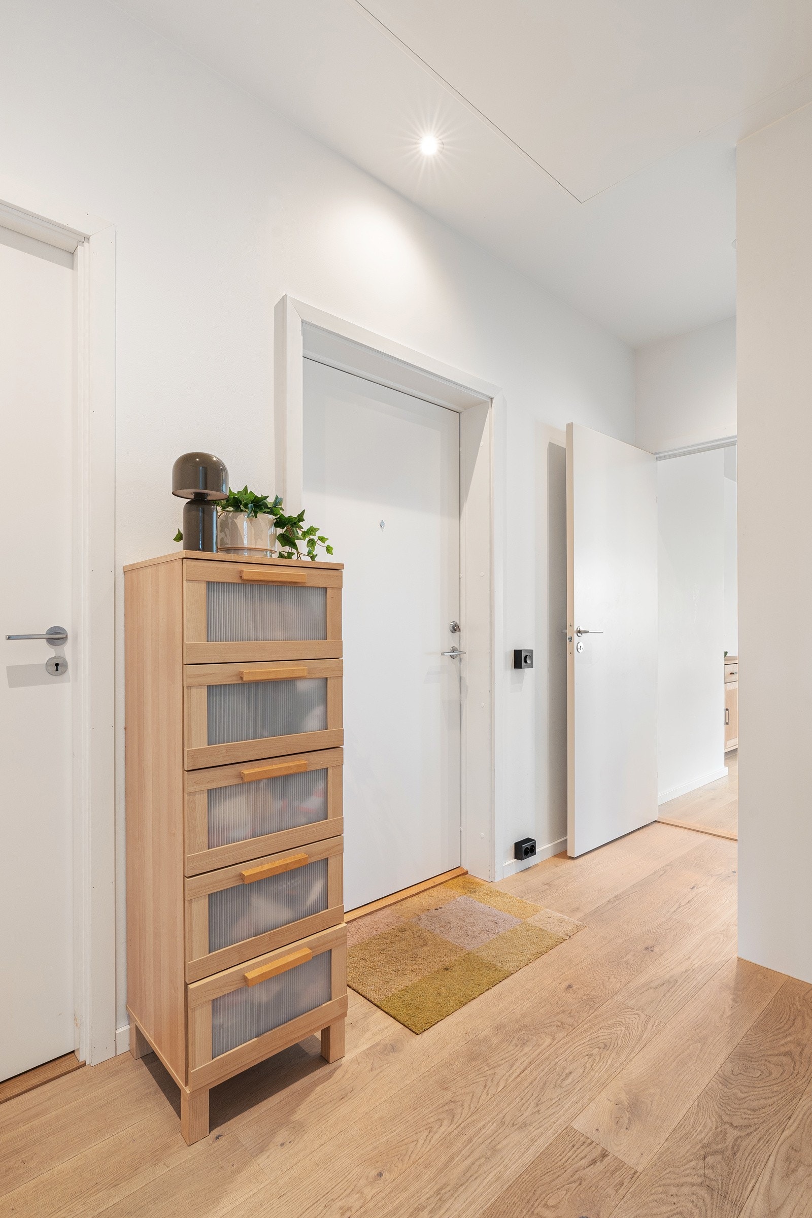Innbydende entré med downlights i himling. Leiligheten ligger i 4. etasje og det er heis i bygget