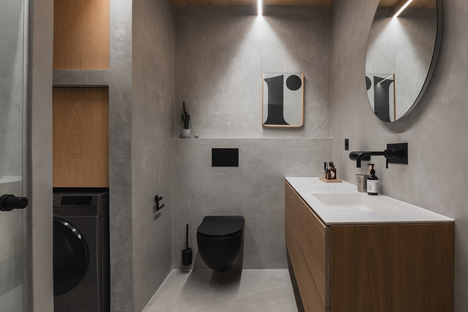 Badet er utført i gjennomgående mikrosement, med detaljer og himling i eik. Skjult nisje for vaskemaskin. Galleribilde