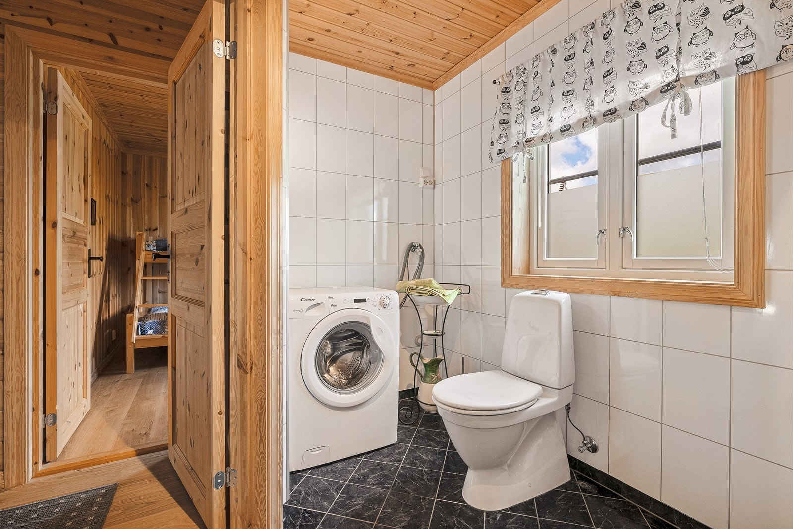 Badet inneholder heldekkende servant med møblement, dusj, toalett, og opplegg for vaskemaskin. Galleribilde