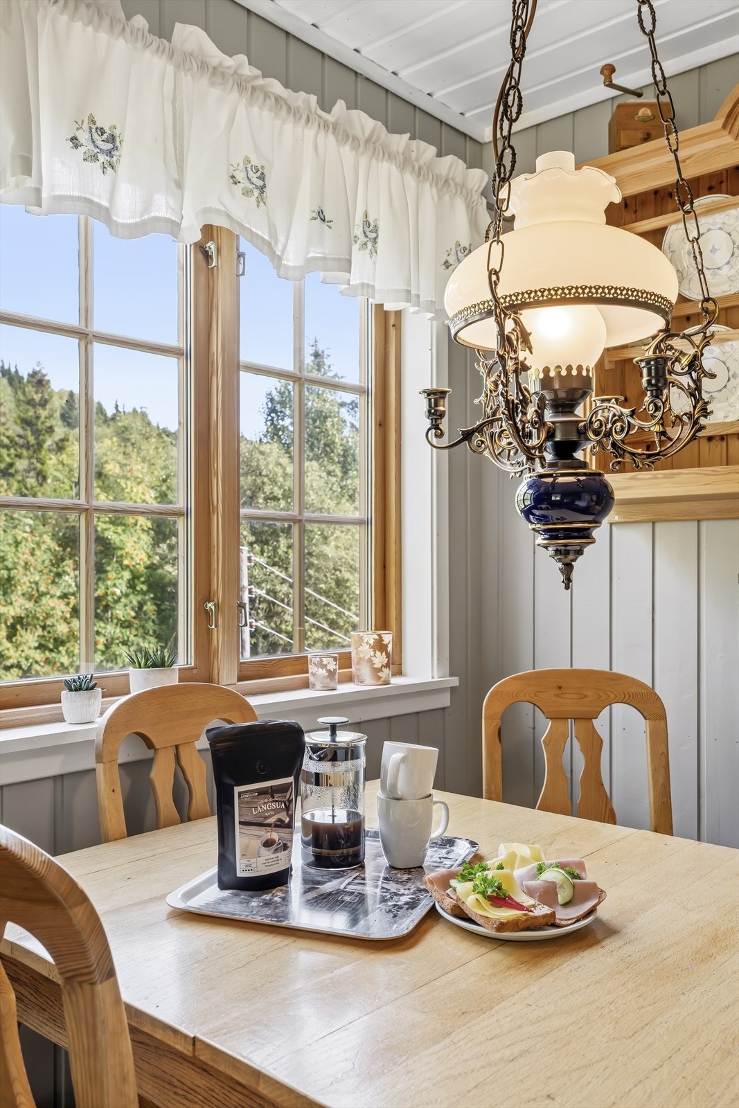 Her ligger alt til rette for å nyte morgenkaffen med flott utsikt mot den vakre naturen utenfor. En rolig og idyllisk start på dagen, omgitt av naturskjønne omgivelser. Galleribilde