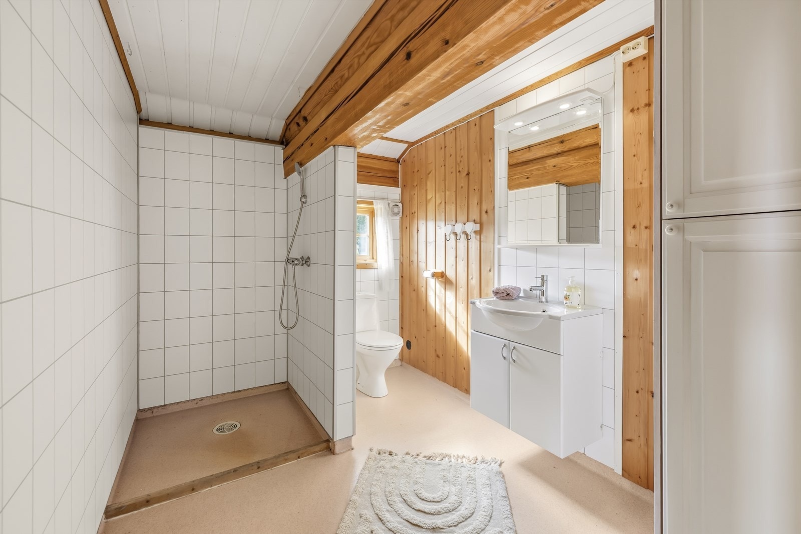 Badet er praktisk og romslig, og er innredet med toalett, servant med underskap og en egen dusjsone. | Etter fotografering har eier installert et dusjkabinett i dusjsonen - se neste bilde for nærmere presentasjon. Galleribilde