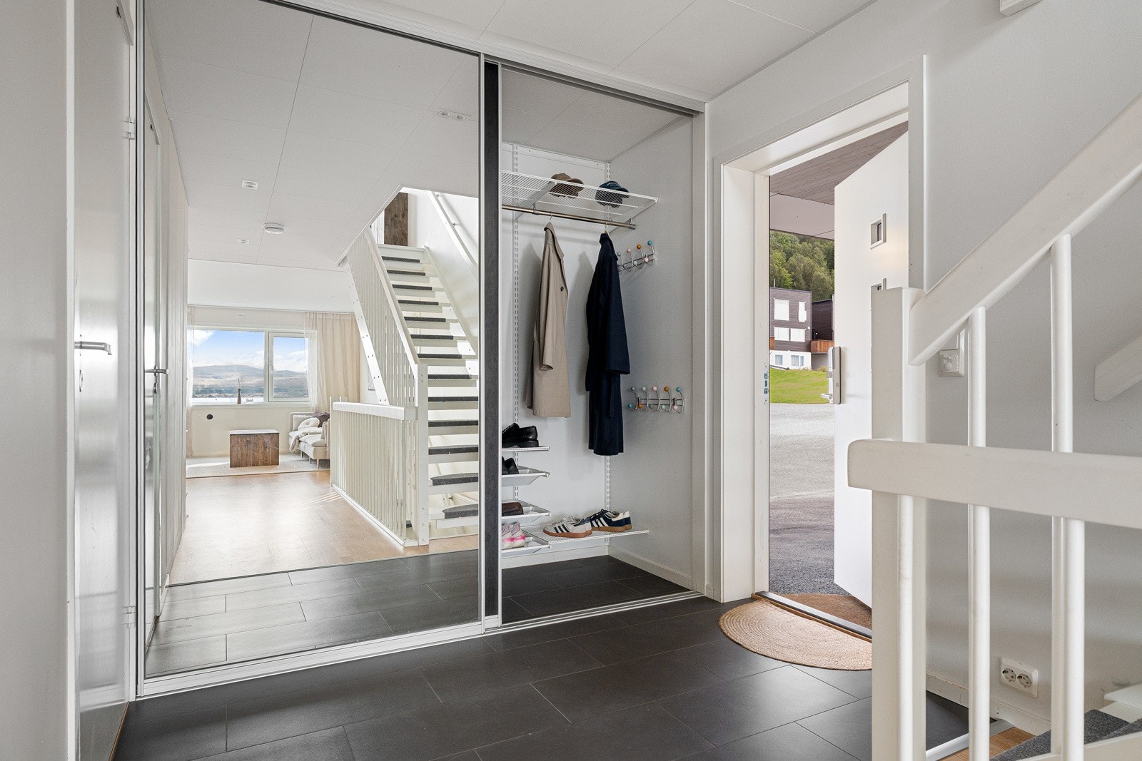Velkommen inn! Strøkent inngangsparti med en stor og praktisk skyvedørsgarderobe.