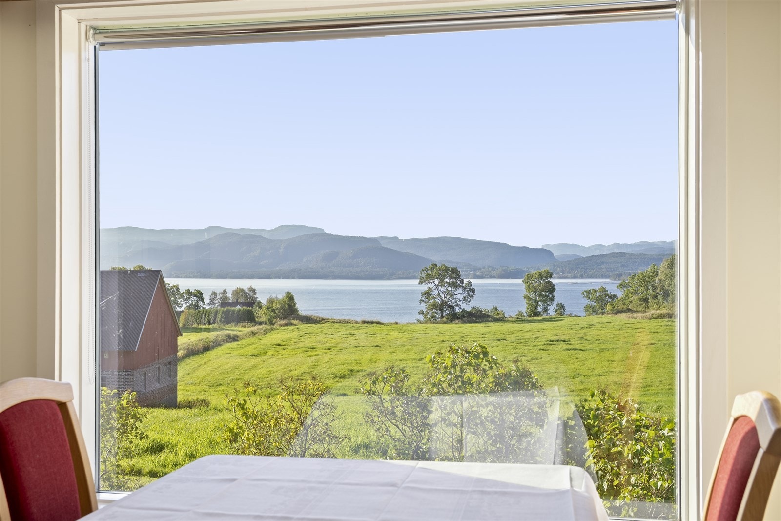 Frå stova er det vidt utsyn over kulturlandskapet og fjorden. Galleribilde