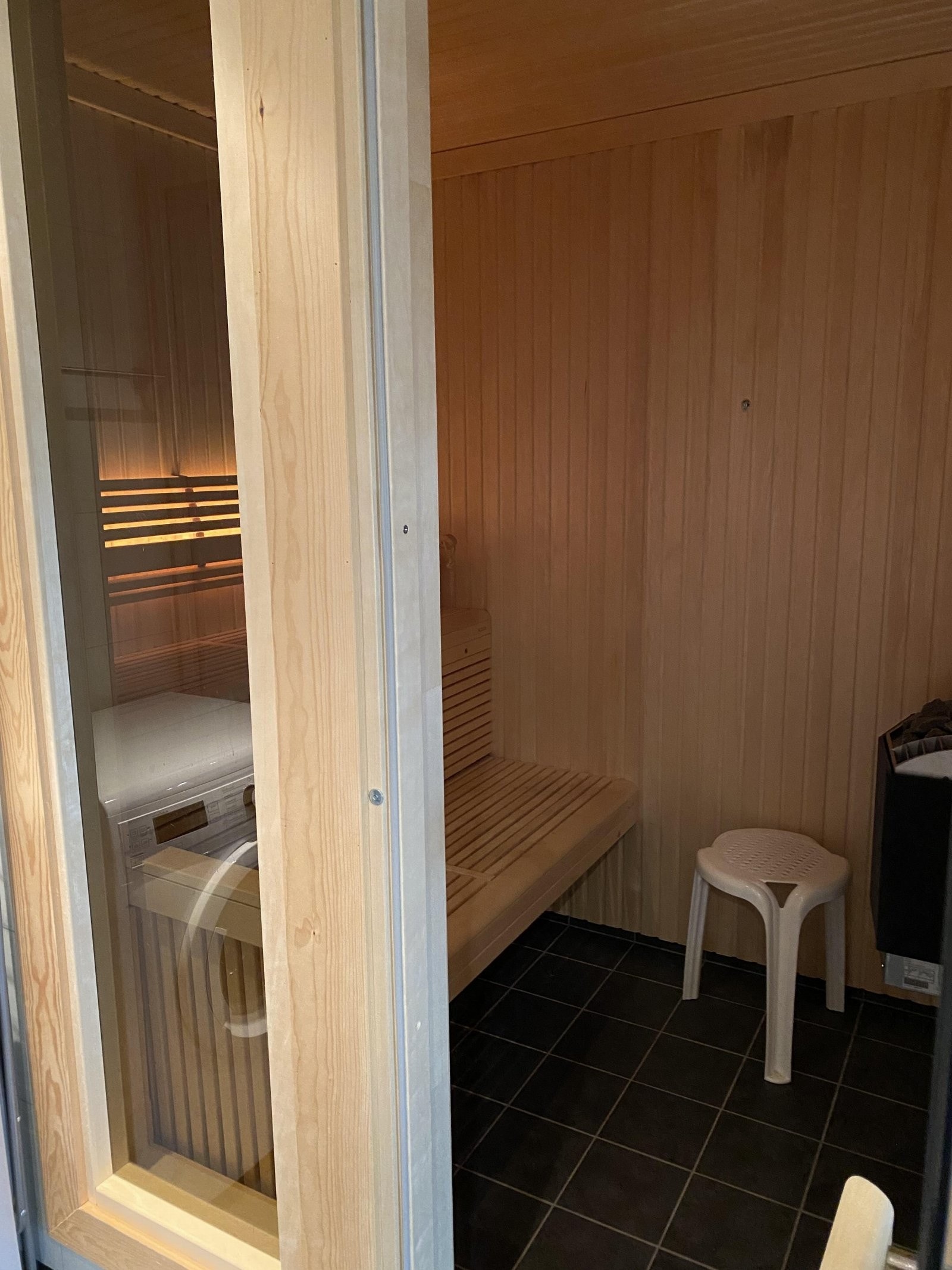 Badstue med flislagt gulv og elektrisk badstueovn.