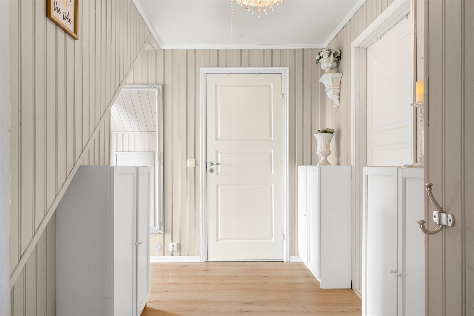 Malt panel og lyse gulv går igjen i boligen for et lunt og lyst inntrykk. Galleribilde