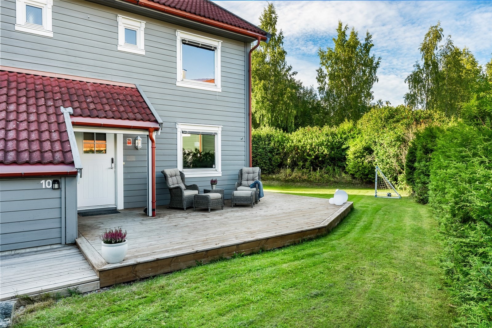 Koselig terrasse ved inngangspartiet, med plass til utemøbler. Terrassen strekker seg rundt boligen, hele veien til baksiden. Foto:Stefan Borup Galleribilde