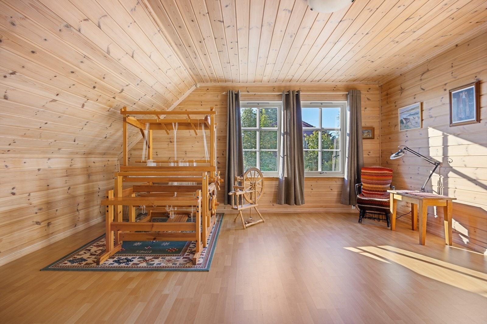 Romslig hall på loftet med panelkledde vegger og tak. Galleribilde