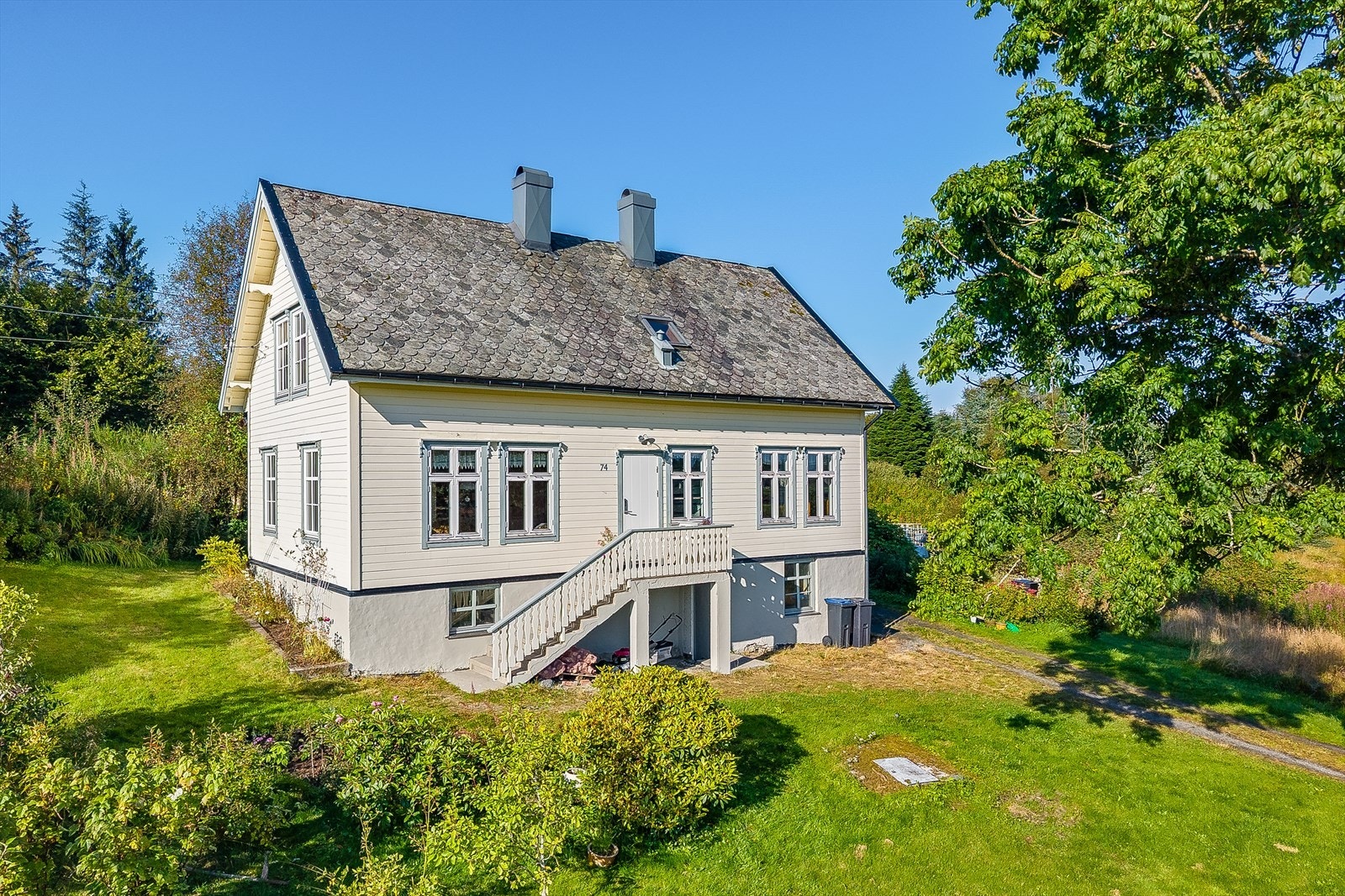 Småbruk med et klassisk våningshus fra ca. 1925, beliggende i landlige omgivelser. Galleribilde