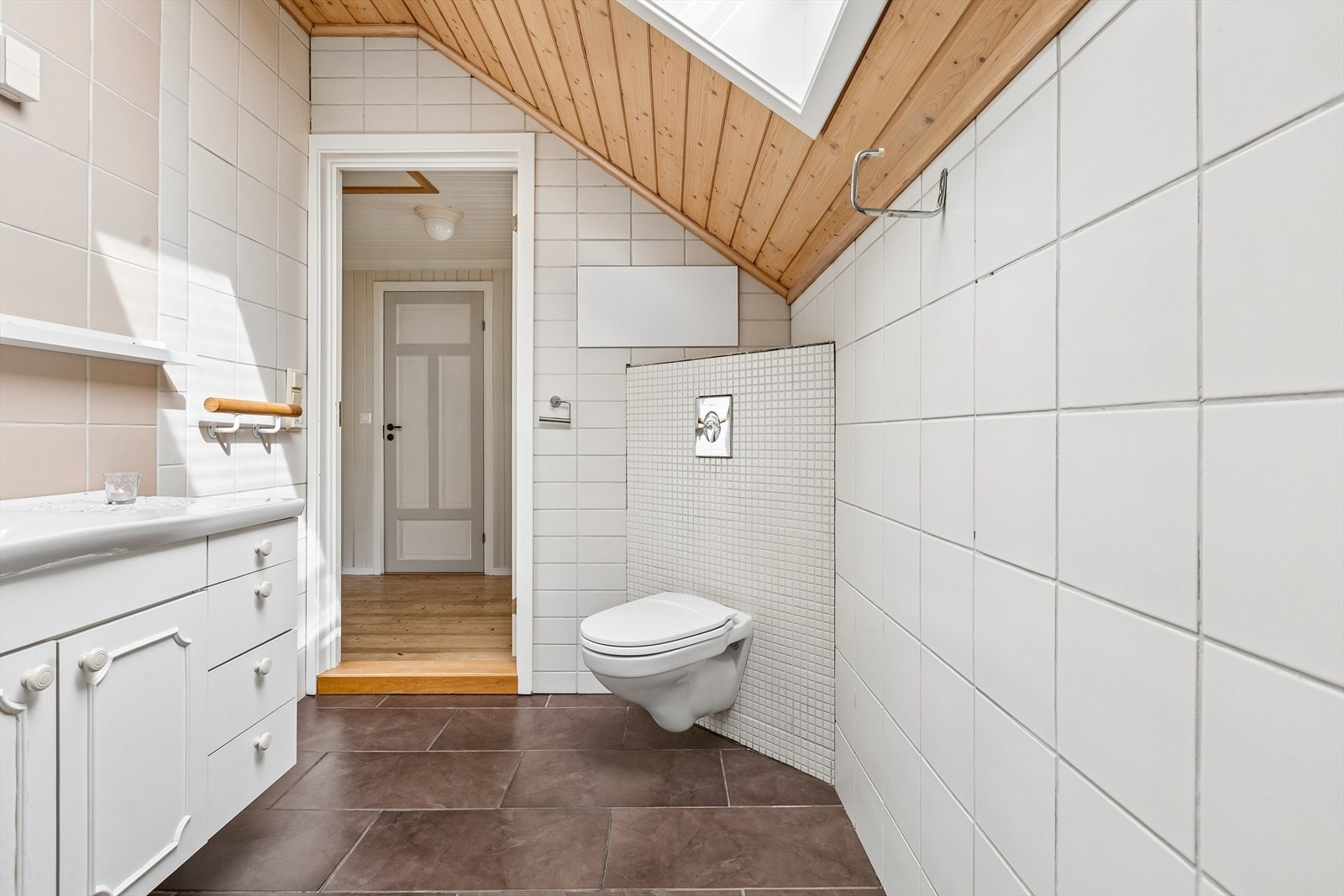 Badet er innredet med vegghengt toalett med innebygget sisterne. Galleribilde