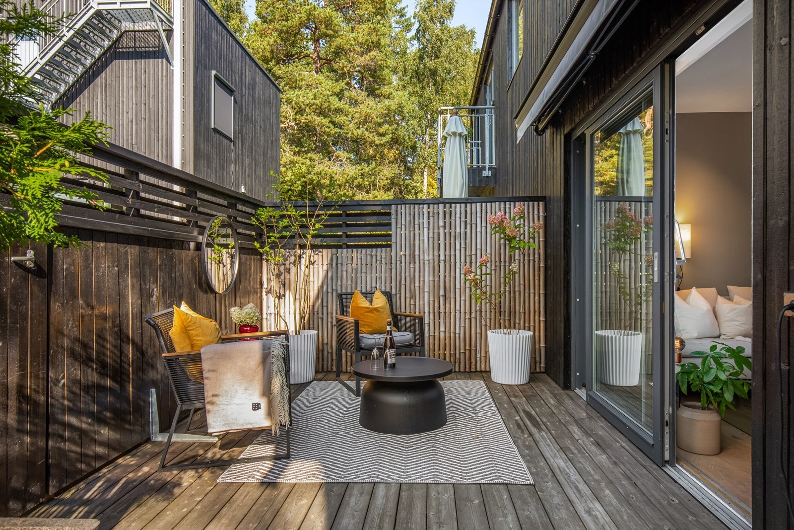 Terrassen er kledd med kebony terrassebord og er skjermet med levegger mot fellesareal Galleribilde