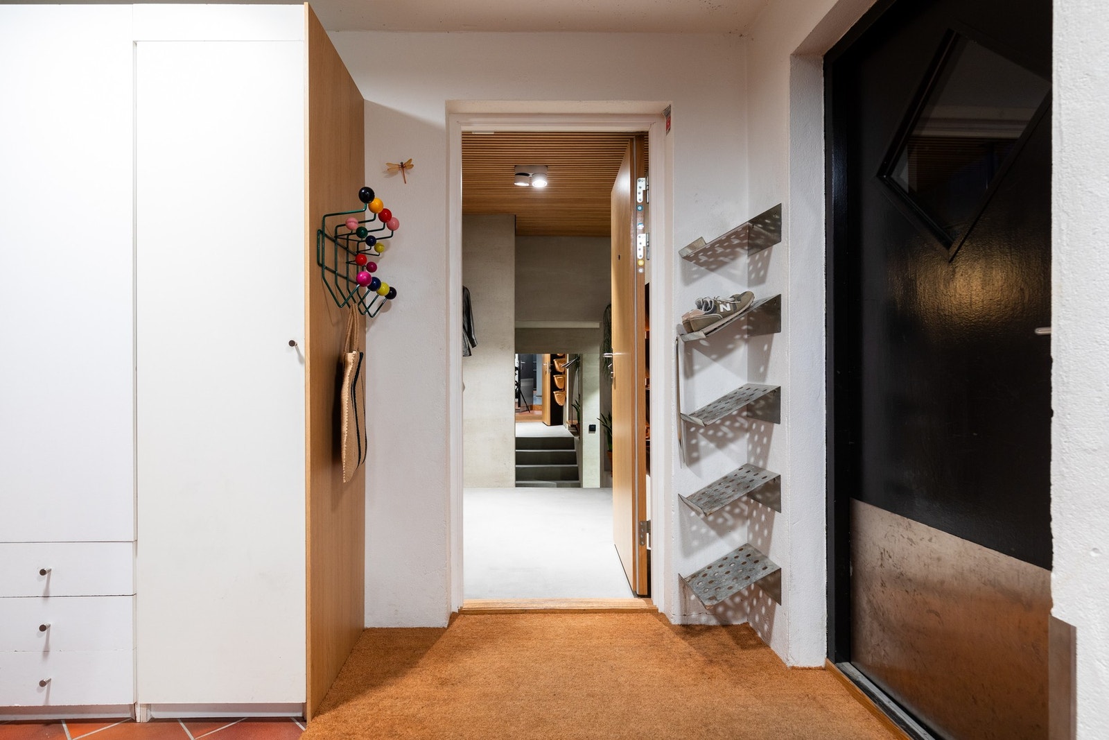 Utenfor inngangsdøra til leiligheten er det to garderobeskap og skohyller. Galleribilde