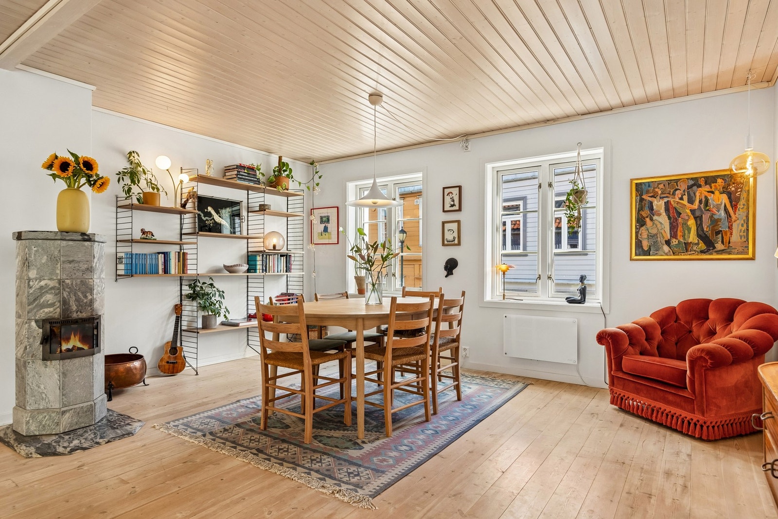 Spiseplassen er naturlig integrert i oppholdsrommet, med vedovn som et stemningsskapende blikkfang og treverk som tilfører interiøret varme og karakter. Galleribilde