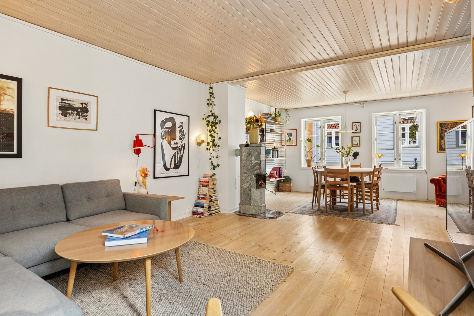 Den åpne løsningen mellom stue og spiseplass skaper en fin sammenheng i oppholdsrommet, samtidig som vedovnen blir et naturlig midtpunkt mellom sonene. Galleribilde