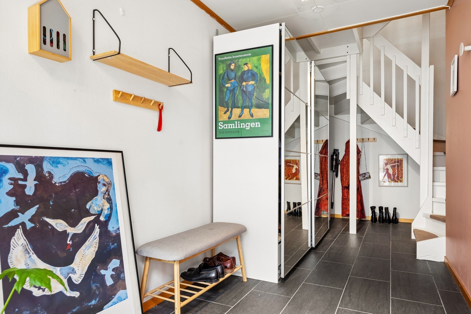 Entréen byr på gode oppbevaringsmuligheter med en stor speilgarderobe, mens trappen leder videre opp til boligens øvrige etasjer. Galleribilde
