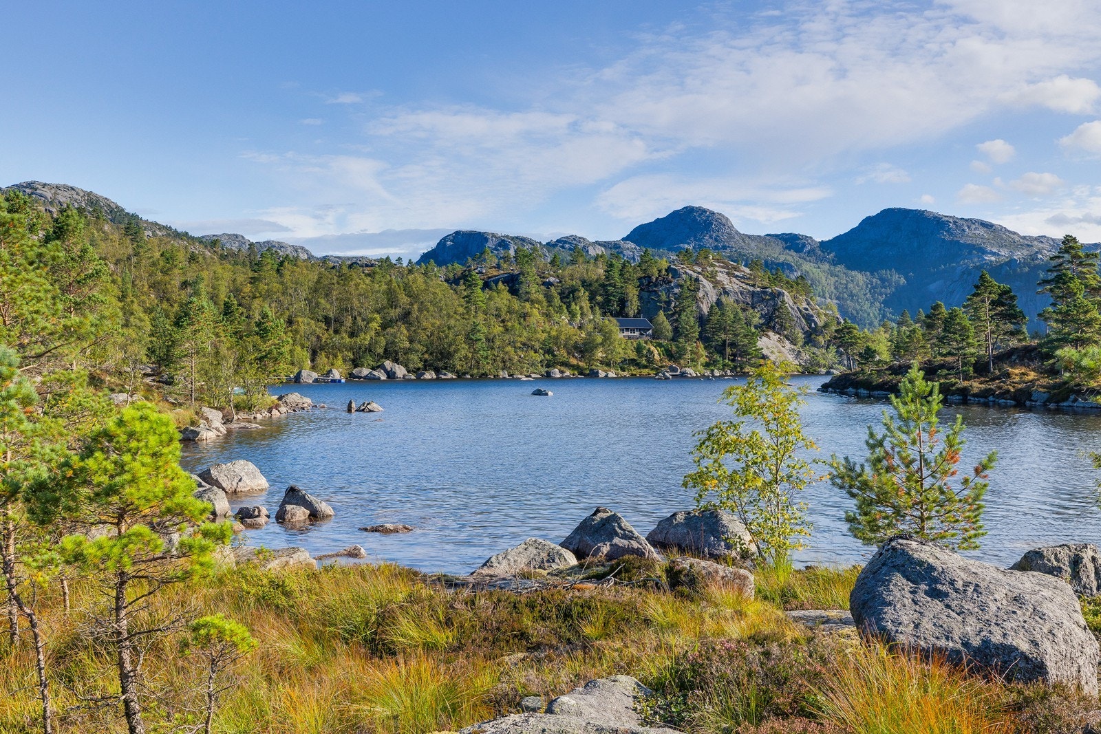 Landskapet byr på vakre kontraster mellom vann, fjell og skog. Galleribilde