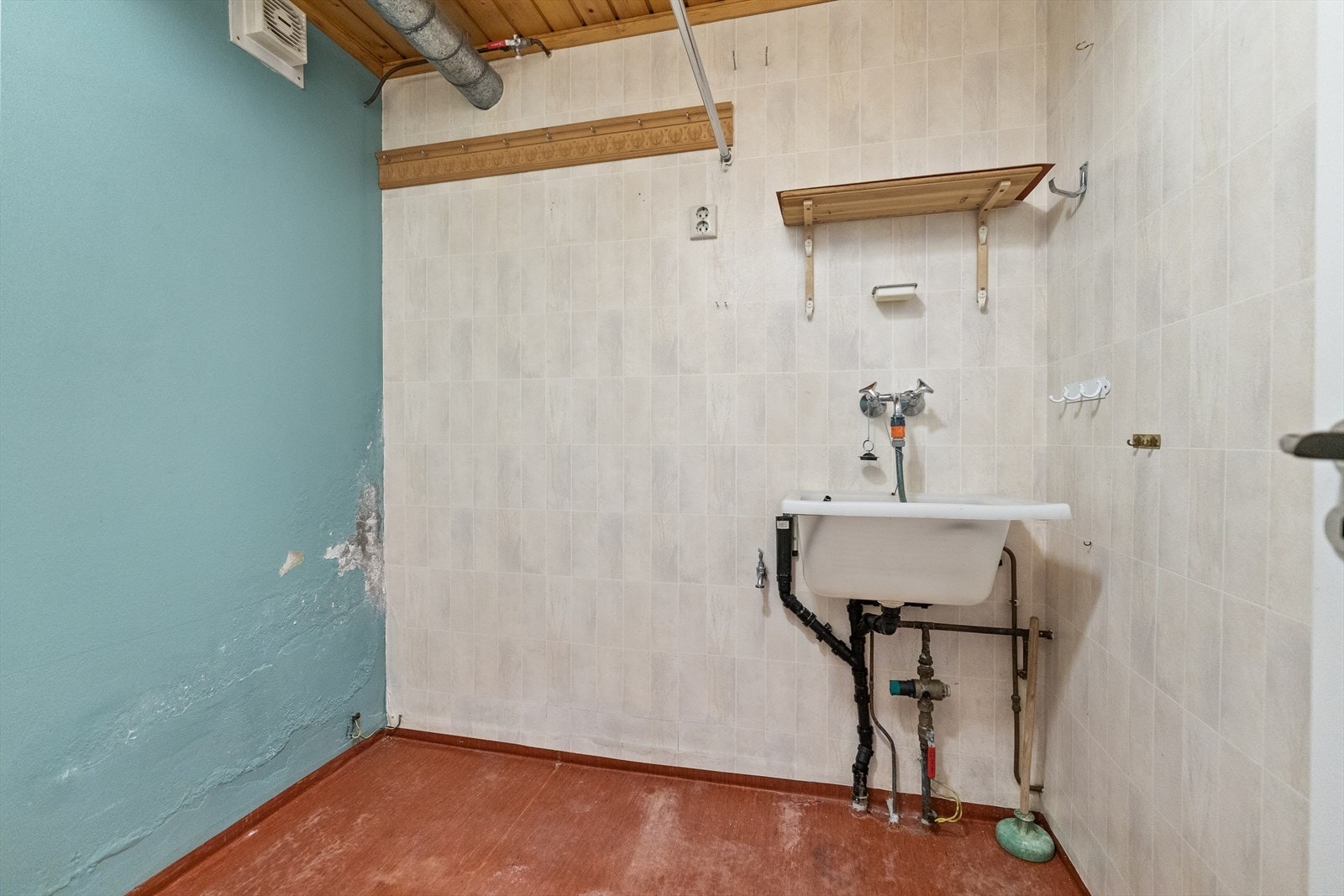 Praktisk vaskerom med opplegg for vaskemaskin, plass til tørketrommel og enkel servant. Galleribilde