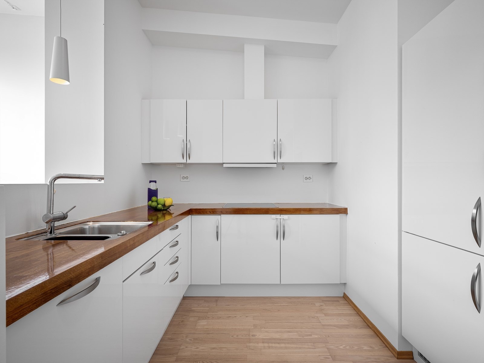 Innredning med glatte, hvite fronter og rikelig med skap- og benkeplass. Galleribilde