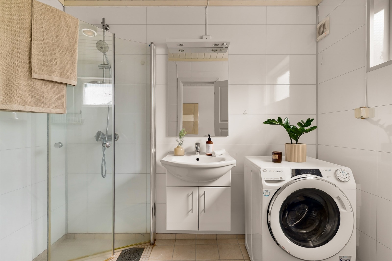 Innbydende bad med flislagt gulv og fulvvarme. Veggene er utført med våtromsplater, og badet har dusjhjørne med dusjvegger samt opplegg for vaskemaskin. Galleribilde