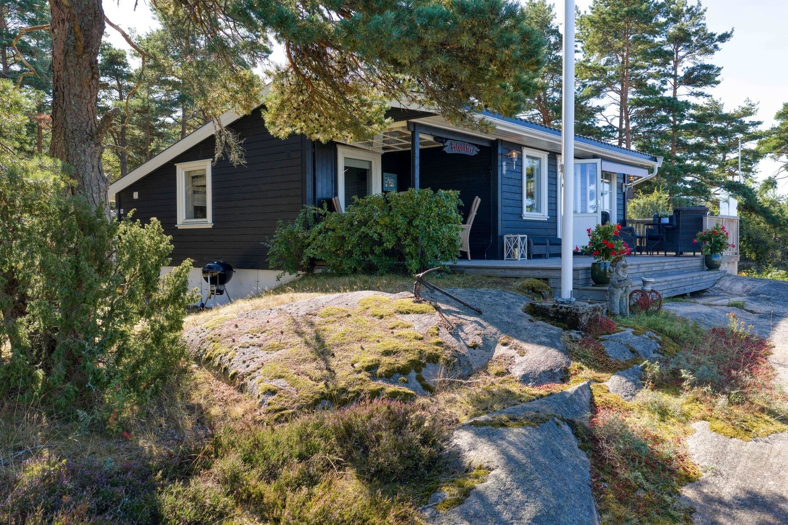 Hytta ligger svært pent blant nydelige furutrær, svaberg og sjø Galleribilde