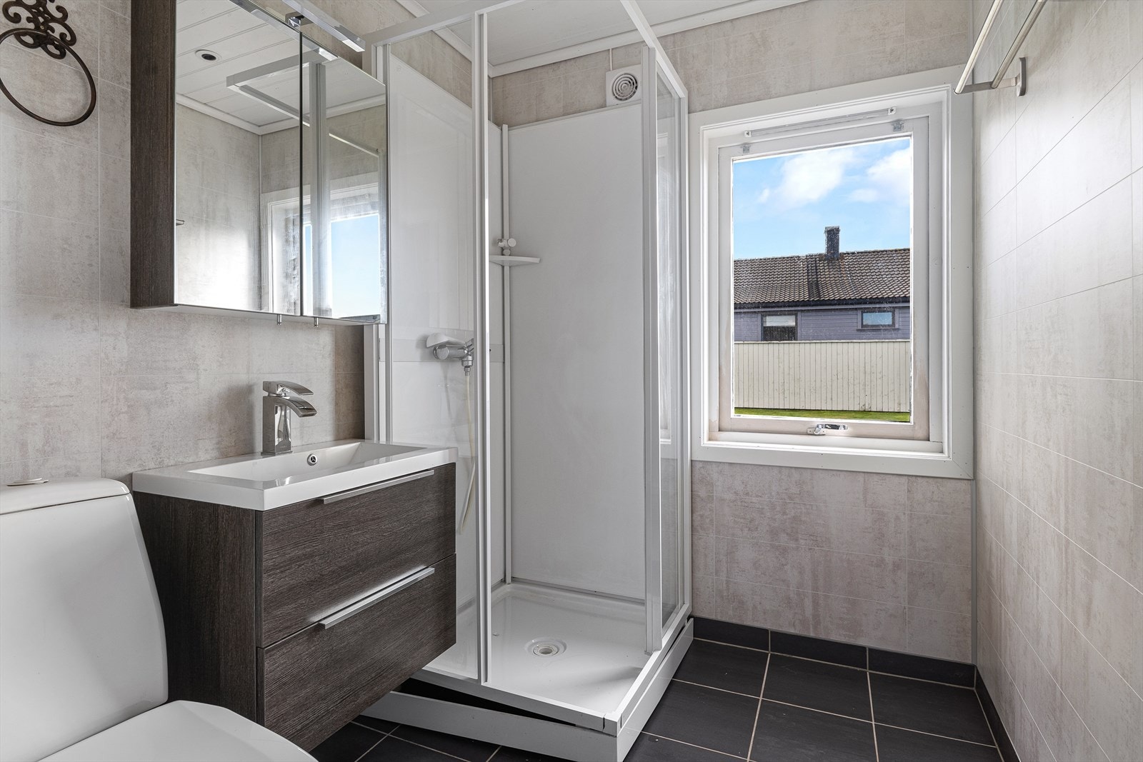 Badet har flislagt gulv med behagelig gulvvarme og våtromsplater på veggene, som ifølge eier ble montert i 2016. Rommet er innredet med servant med oppbevaring, toalett og dusjkabinett. Galleribilde