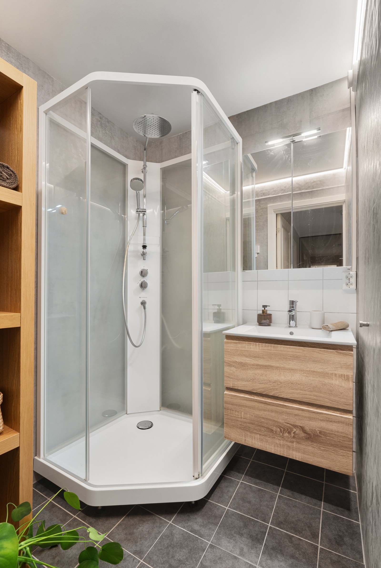 Badet på plan 2 er utstyrt med dusjkabinett og baderomsinnredning med oppbevaringsplass.
