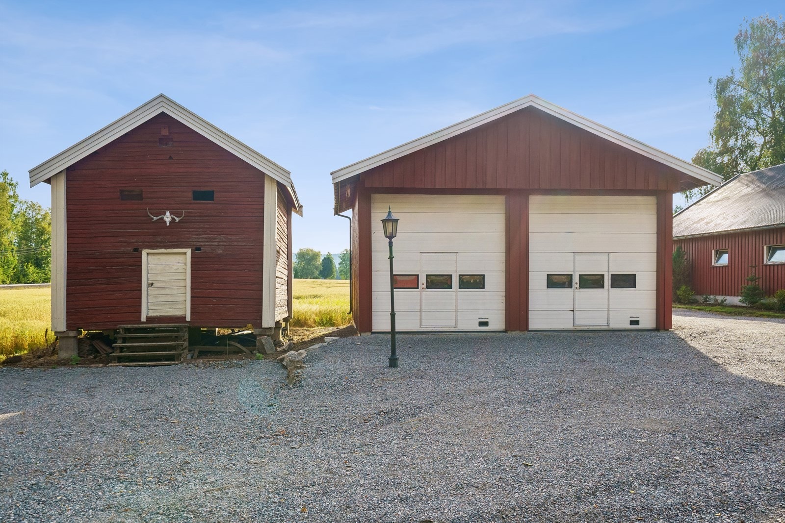 Dobbelgarasje med to leddporter med el-motor - Stabbur med trapp til plankedør. Galleribilde