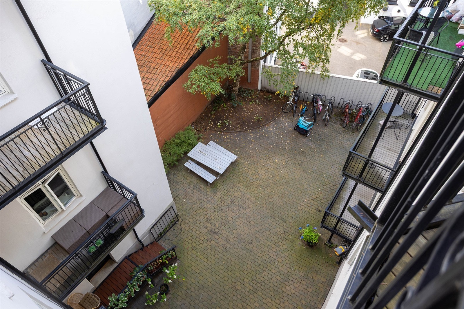 Hyggelig og pent opparbeidet bakgård med sykkelparkering og sittegruppe. Galleribilde