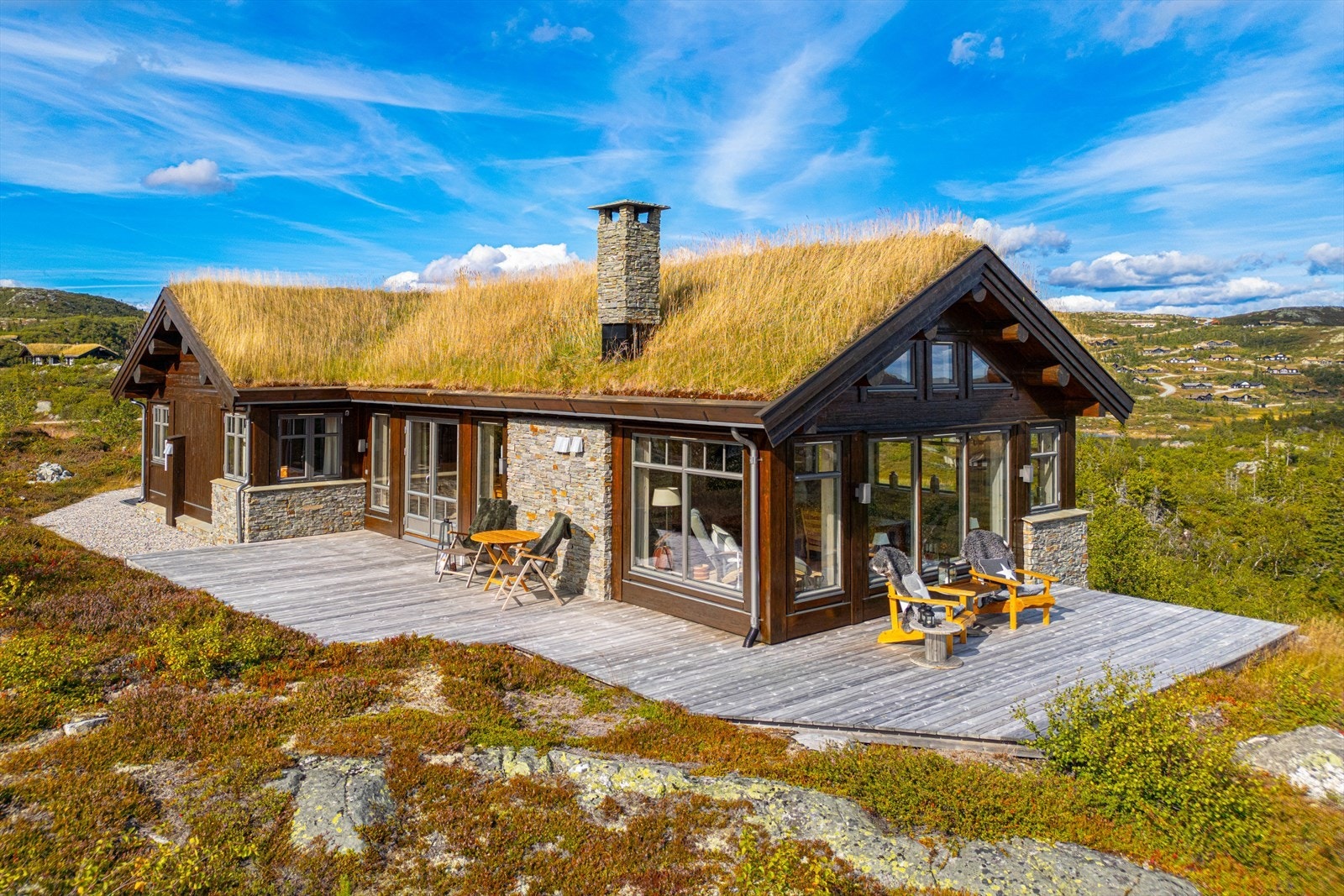 Terrassen strekker seg rundt hytten og har fine soner, god plass til flere sittegrupper og grill. Galleribilde