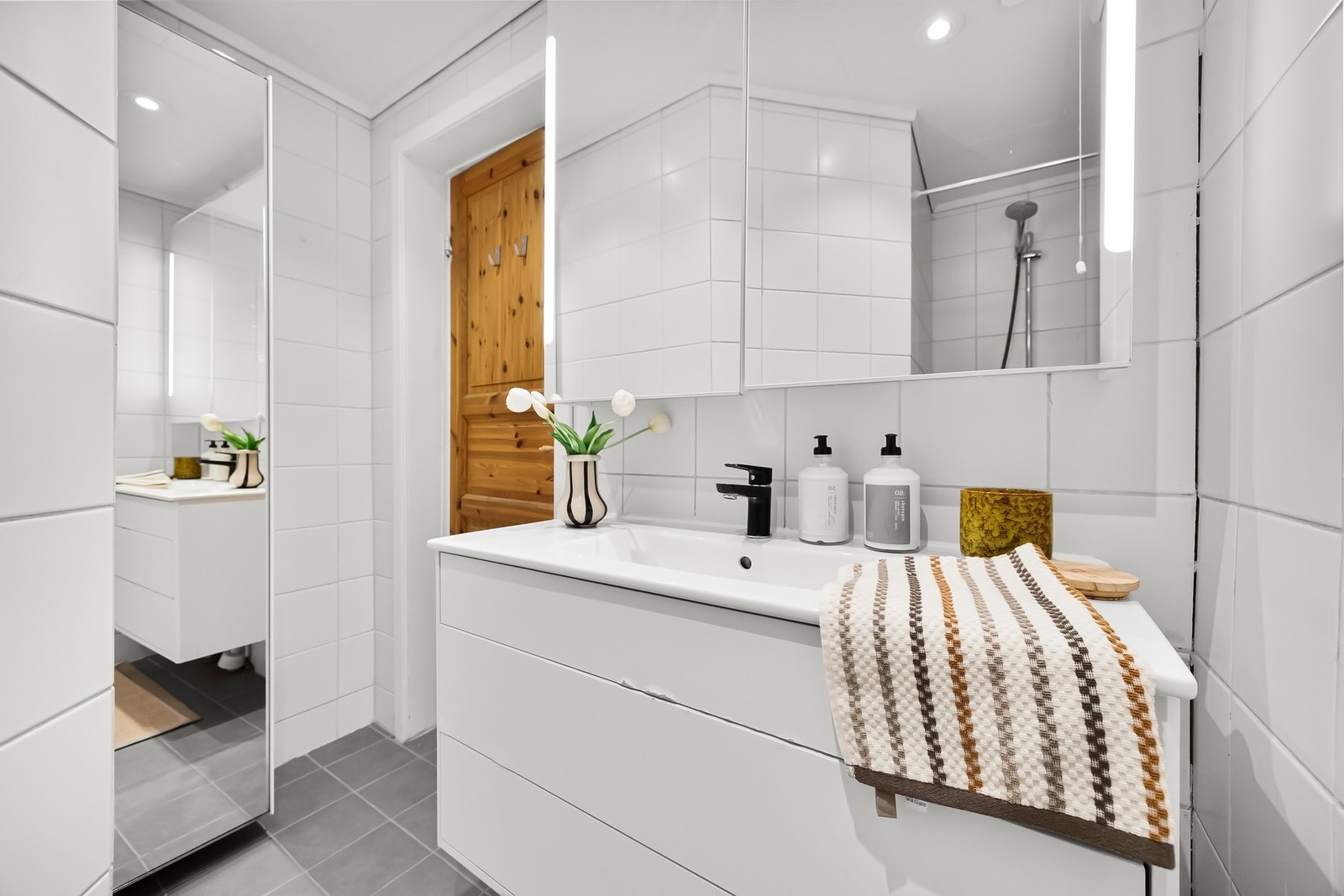 Pent flislagt baderom med varmekabler. Badet inneholder servantinnredning og innfelt dusjnisje. Opplegg for vaskemaskin er i trappebod, like utenfor leiligheten Galleribilde
