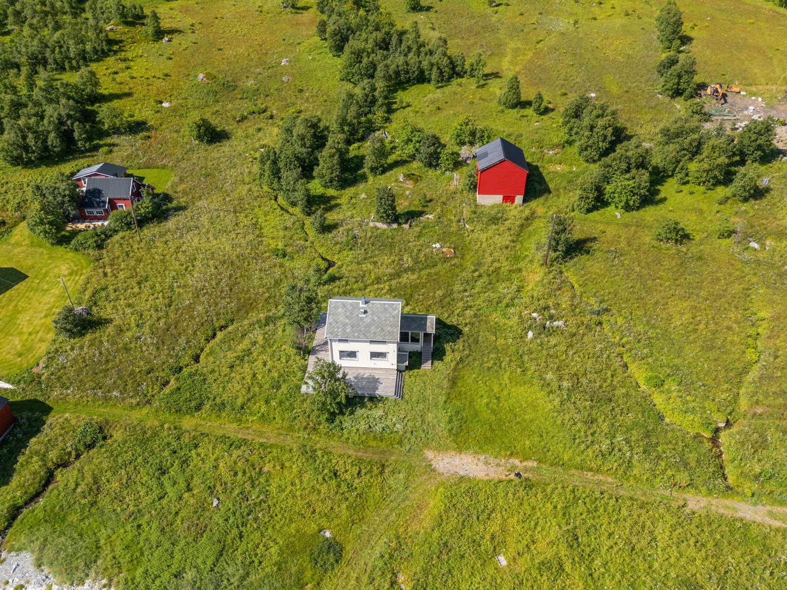 Det åpne landskapet rundt boligen gir lange siktlinjer i flere retninger.