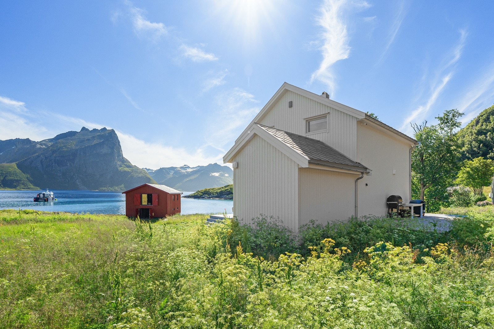 Baksiden av huset med naustet ned mot havet