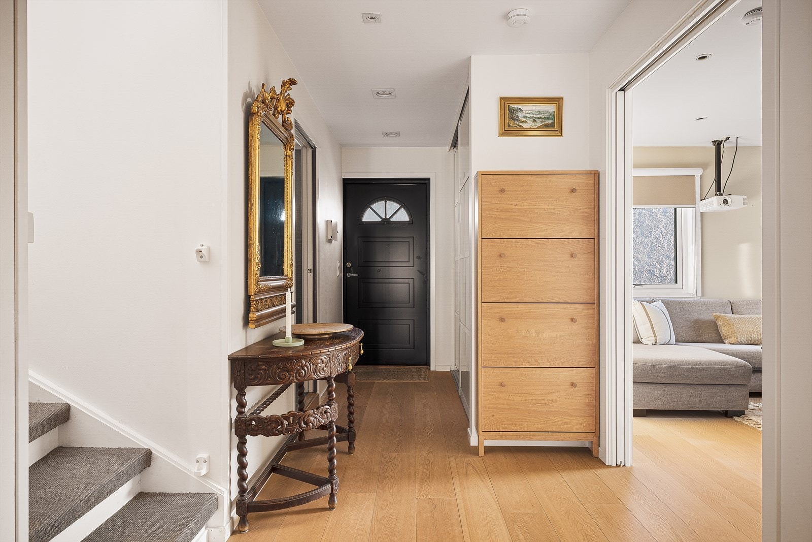 Lys og innbydende entré med parkett på gulv og adkomst til etasjens øvrige rom. Skyvedørsgarderobe i entré. Galleribilde