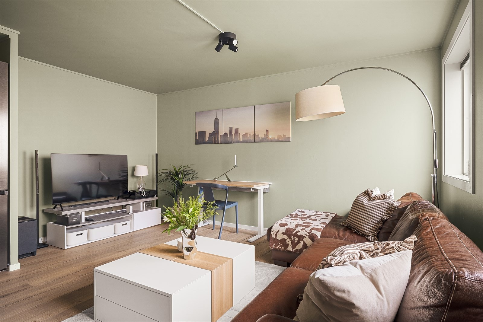 Rommet som er innredet som stue har laminat på gulv og plass til både sofagruppe og spisebord. Galleribilde