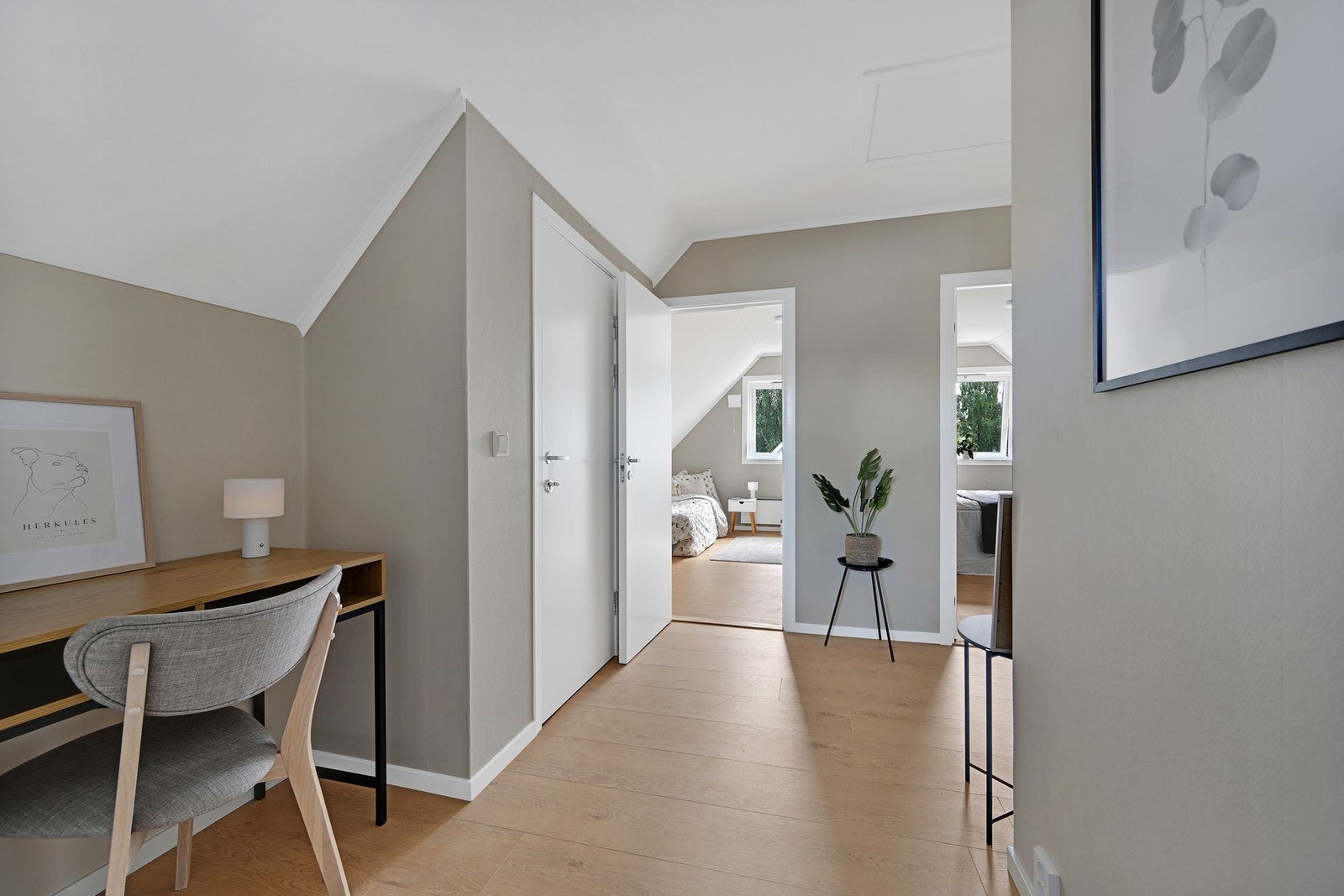 Lys og innbydende gang i øvre etasje med plass til en praktisk kontorplass Galleribilde