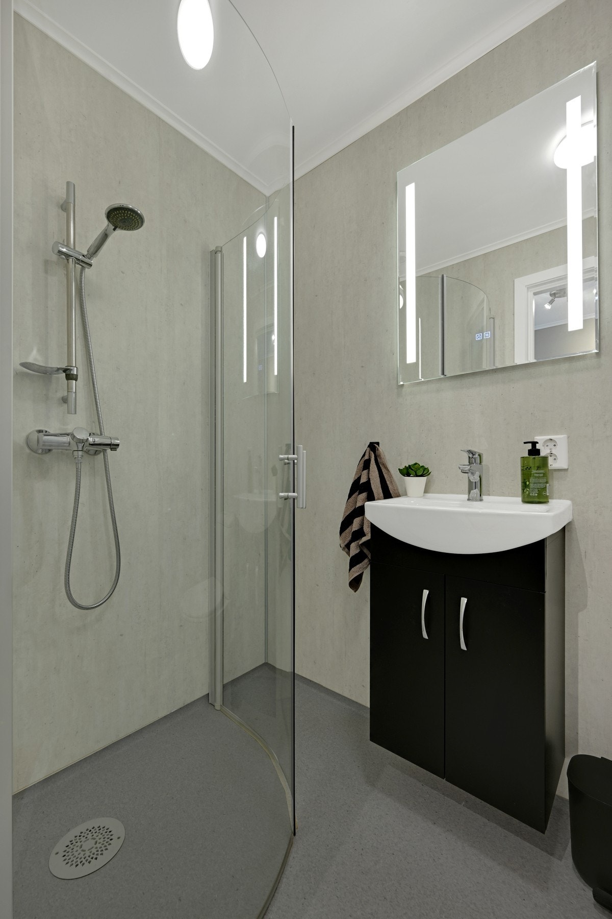 Badet har et stilrent og lettstelt uttrykk med dusjhjørne i glass. Galleribilde