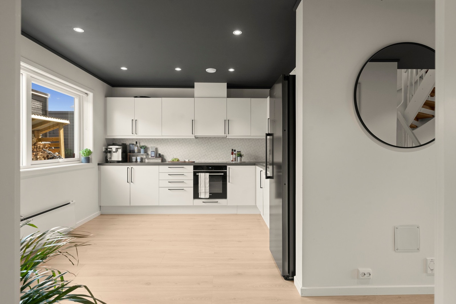 Kjøkkenet har et stilrent og moderne uttrykk med lyse, glatte fronter og benkeplate i laminat. Den gode utformingen byr på rikelig med skap- og benkeplass. Galleribilde